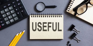 Ofis araçları ile gri bir arkaplan üzerinde yazılar olan not defteri. iş