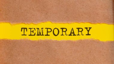 Sarı arkaplanda yırtık kağıdın altında yazan TEMPORARY