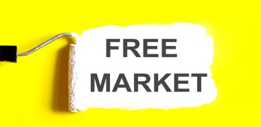 ÖZGÜRLÜK MARKET. Sarı arka planda beyaz fırçalı bir açık boya kutusu.
