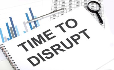 Defterde Time to DisRUPT, büyüteç ve kalemin yanında, arkaplan grafiktir.