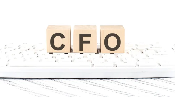 CFO Chief Financial Officer word wooden block on the keyboard background witn chart