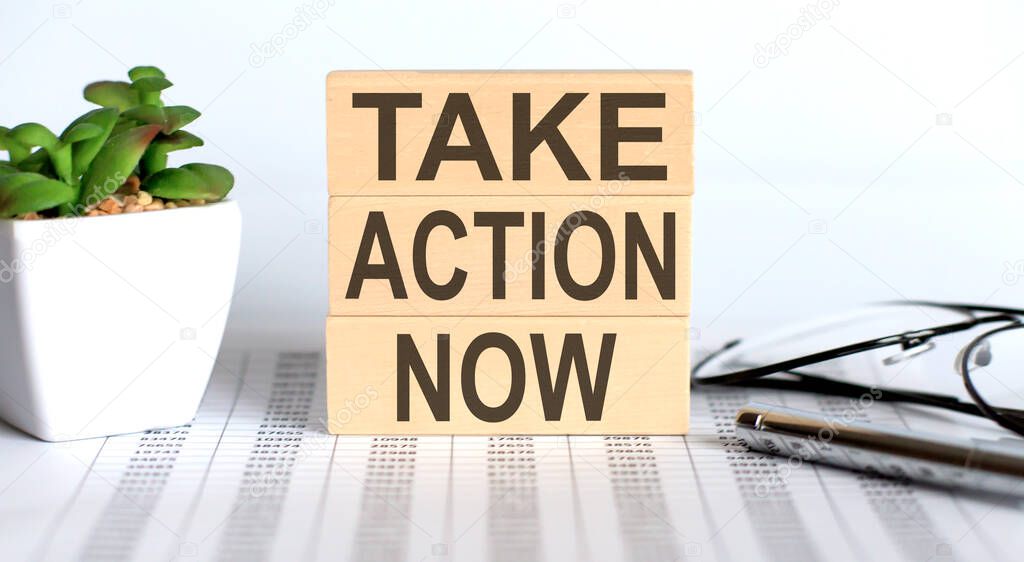 Take Action Now text on wooden cubes on chart