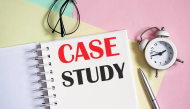 Not defterine kalem ve pembe arkaplanda çalar saat yaz.