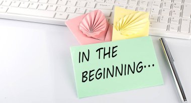 Klavyede beyaz zemin üzerinde kalem olan renkli bir zarf.