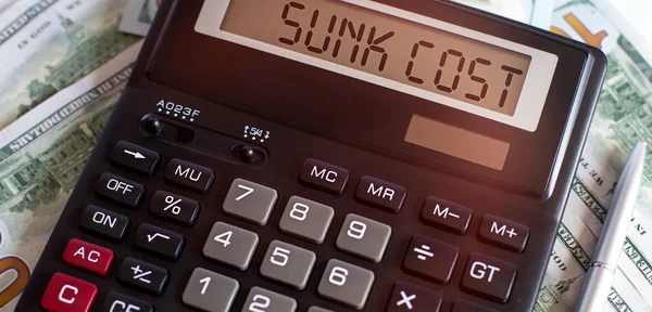 Calculator with text SUNK COST on the dollars. Business, finance conceptual.