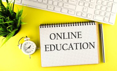 Sarı zemin üzerinde klavye, kalem ve alarm saatiyle çevrimiçi eğitim metni