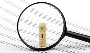 Grafik arka planında ETF tahta küpleri, büyüteçle bakın