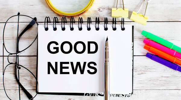 Пустой блокнот и очки на сером столе. ДОБРЫЕ NEWS