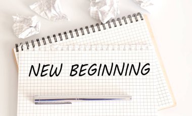Not defterinde beyaz arkaplanda yeni bir başlangıç metni. İş dünyası