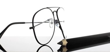 Beyaz arkaplanda izole edilmiş gözlük ve kalem