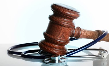 Gavel ve Stetoskop seçici odaklı beyaz arkaplanda.