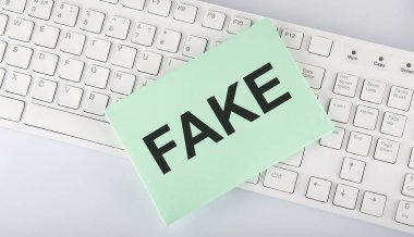 Beyaz arkaplan üzerinde klavye üzerindeki zarf üzerinde sahte metin