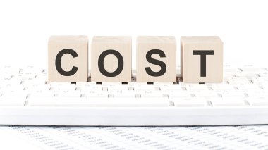 Klavye arkaplan witn grafiğinde COST sözcüğü tahta blok