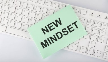 Beyaz arkaplanda klavyede zarf üzerinde NEW Mindset metni