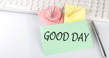 Klavyede beyaz arkaplanda renkli zarflar üzerinde İyi Günler metni