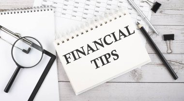 Finans bahşişleriyle. Ofis araçları ve belgelerle not defterine yazılan metin.