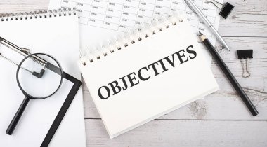 OBJECİSLER. Not defterine ofis araçları ve belgelerle yazılmış metin.