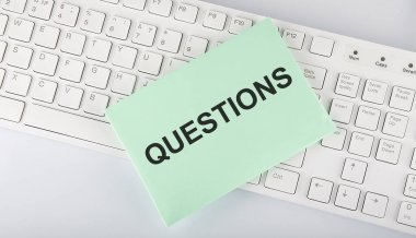 Beyaz arkaplan üzerinde klavye üzerindeki zarf üzerinde soru işaretleri