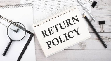 Masaüstünde kalem, ofis araçları ve grafikler ile metin RETURN POLICY ile Not.