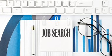 Klavyesi, çizelgesi, gözlüğü ve kalemi olan bir ofis masası. Üst görünüm metin görev araması