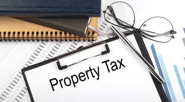 Ofis masasının üzerinde beyaz arkaplan üzerinde not defterleri, malzemeler, analiz çizelgesi bulunan metin Özellikleri Vergisi.