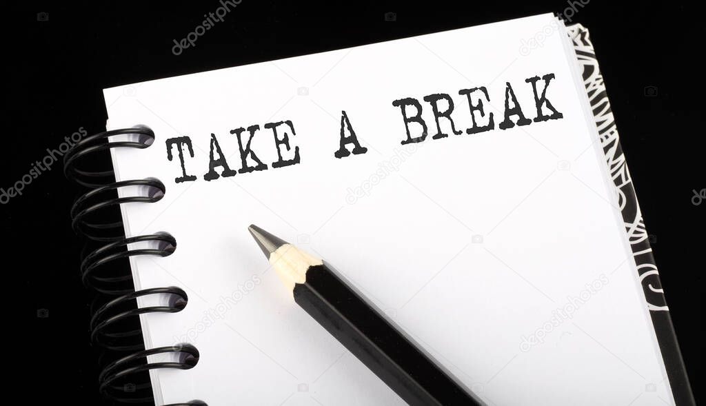 TAKE A BREAK written text in small notebook on black background