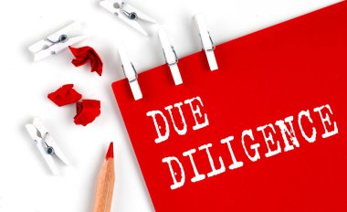 DOE DILLIGENCE beyaz arka planda ofis araçları ile kırmızı kağıt üzerinde metin