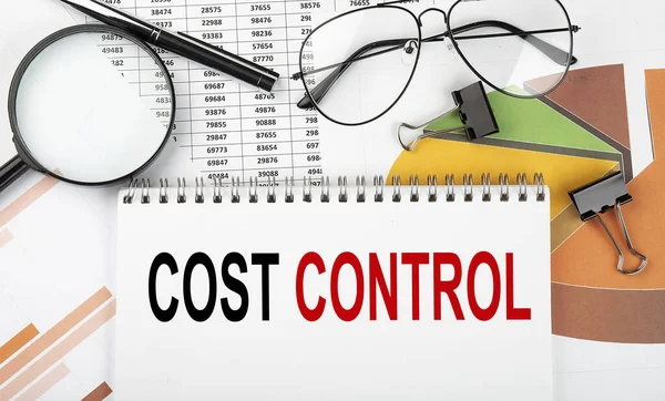 Text COST CONTROL on white paper notebook on the diagram. Business