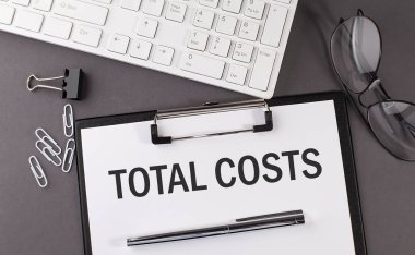 Ofis kâğıdında TOTAL COSTS ve klavye yazılı. İş dünyası
