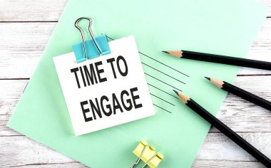 Kısa notta, tahta arka planda kalemlerle bağlanma zamanı