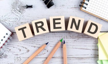 Tahta blokta TREND metin ve ahşap arka planda ofis araçları