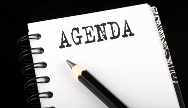 AGENDA siyah arkaplan üzerine küçük not defteriyle metin yazdı