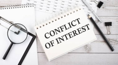 Masaüstünde kalem, ofis araçları ve grafiklerle INTEREST 'in metin CONFLICT' i.