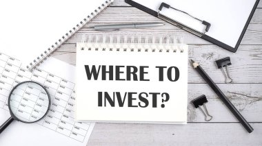 Masaüstünde kalem, ofis araçları ve grafikler ile INVEST nereye metin.