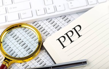 Not defterindeki PPP metni çizelge, büyüteç, klavye ve kalemle