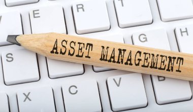Klavye arkaplanındaki kalem üzerine ASSET MANAGEMENT metni