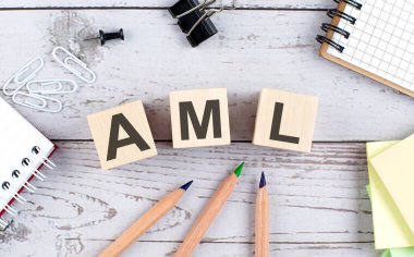 Ahşap blokta AML metin ve ahşap arka planda ofis araçları
