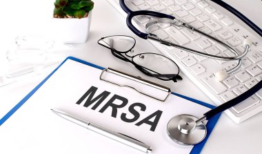 Beyaz arkaplanda MRSA metni var. steteskop, gözlük ve klavye