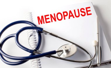 Metin MENOPAUSE ile defter kalem ve steteskop, tıbbi