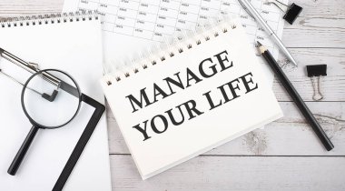 Yaşamını yönet. Not defterine ofis araçları ve belgelerle yazılmış metin.