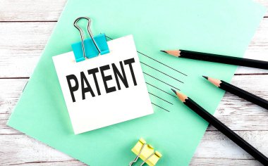 Tahta arka planda kalemler ile kısa nota PATENT metin