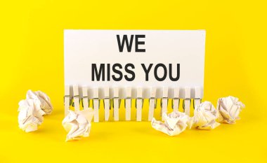 Beyaz kısa not kağıdı sarı arka planda seni özlüyoruz.