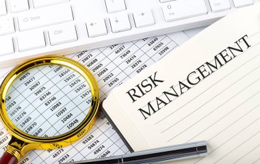 Not defterine çizelge, büyüteç, klavye ve kalemle birlikte RISK MANAGEMENT metni