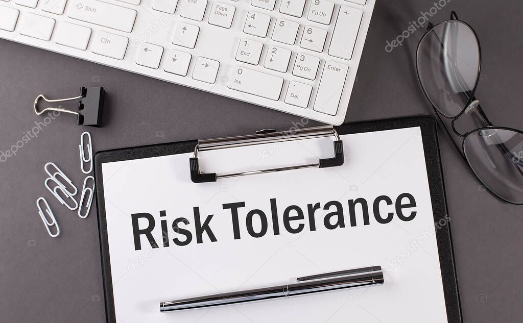 Office paper sheet with text RISK TOLERANCE and keyboard. Business