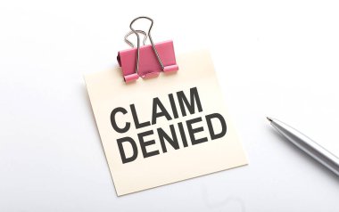 CLAIM DENIED beyaz arkaplanda kalem etiketli metin