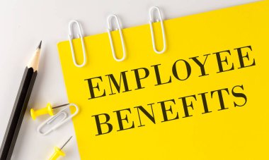 Beyaz arka planda ofis araçları ile sarı kağıt üzerinde EMPLOYEE BENEFITS kelime