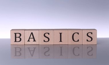 Gri arkaplanda izole edilmiş yapı taşlarıyla yapılmış BASICS sözcüğü
