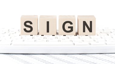 Dizüstü bilgisayarın arkasındaki tahta bloktaki SIGN metni