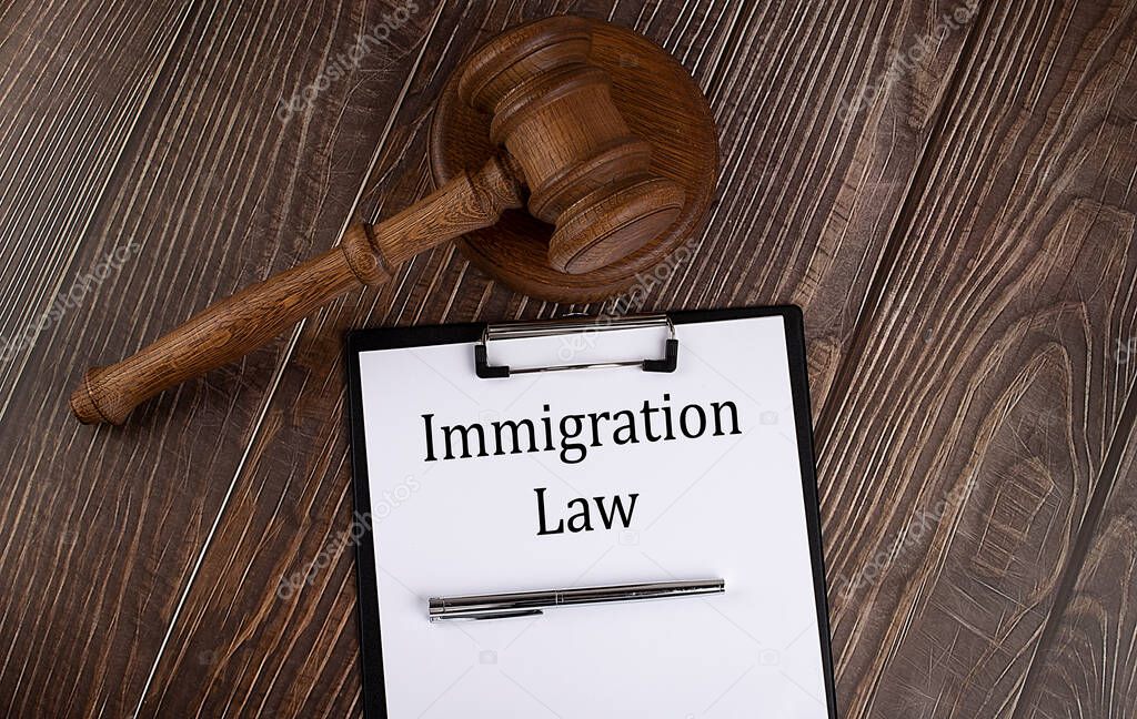 IMMIGRATION LAW text on the paper with gavel on the wooden background