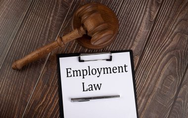 Kağıt üzerinde ahşap zemin üzerinde tokmak olan İstihdam Hukuku metni